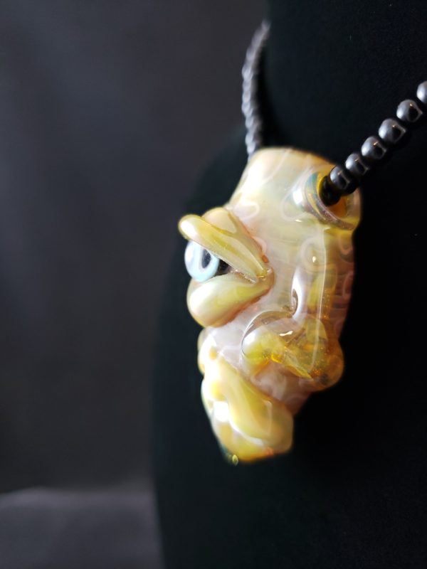 Lampwork glass creature pendant side view of blue eye nose and mouth with teeth