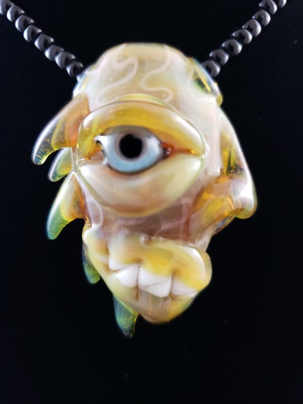 Blue eyed glass creature lampwork pendant with spines on the back