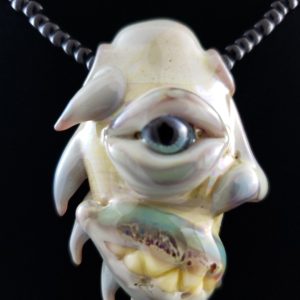 Glass Creature Face Pendant with blue eye spikes and teeth