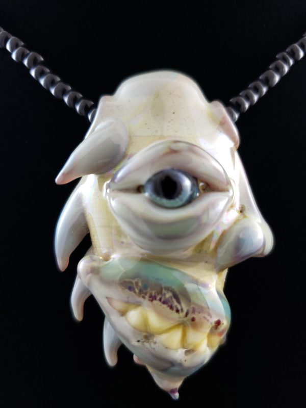 Glass Creature Face Pendant with blue eye spikes and teeth