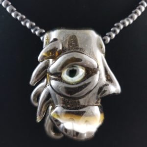 dark amber color glass creature pendant with UV reactive eye