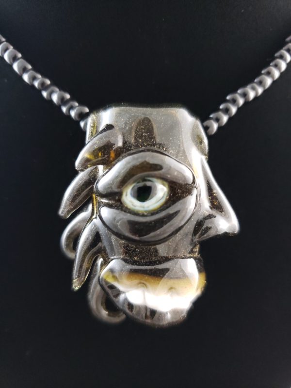 dark amber color glass creature pendant with UV reactive eye