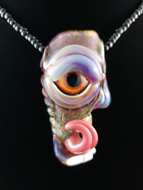 orange and yellow eye glass creature pendant with curled tongue multi colored body