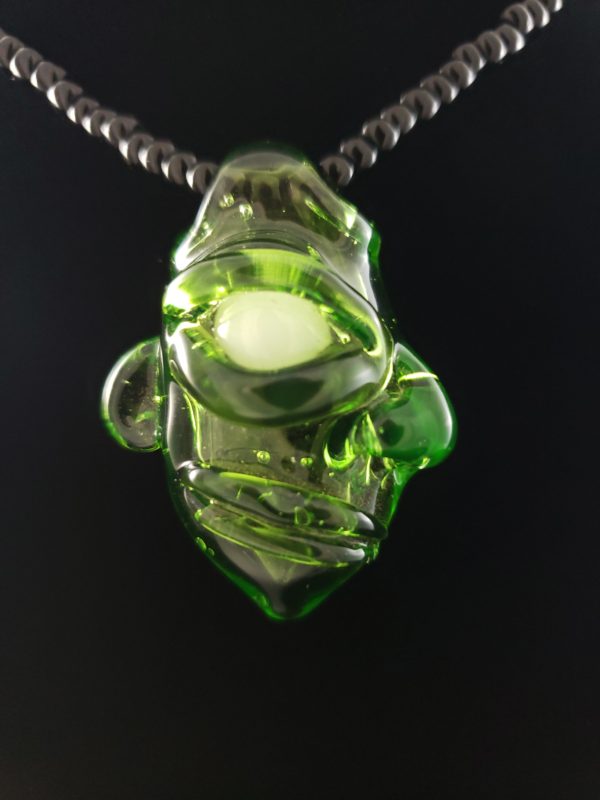 hollow clear green glass creature face pendant with white ghost eye