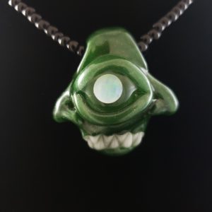 opaque green glass two face creature pendant with opal eye and white teeth